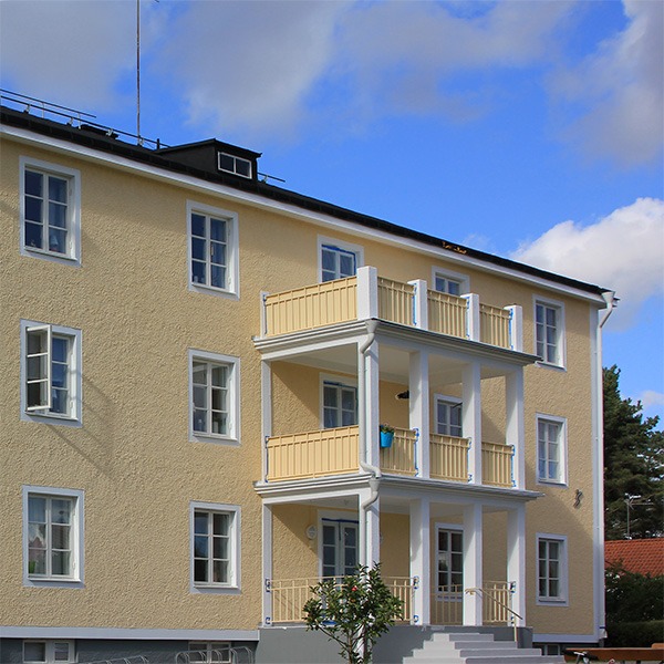 Freundliche Fassadenfarbe mit Energiesparwirkung an einem Wohnhaus in Schweden.